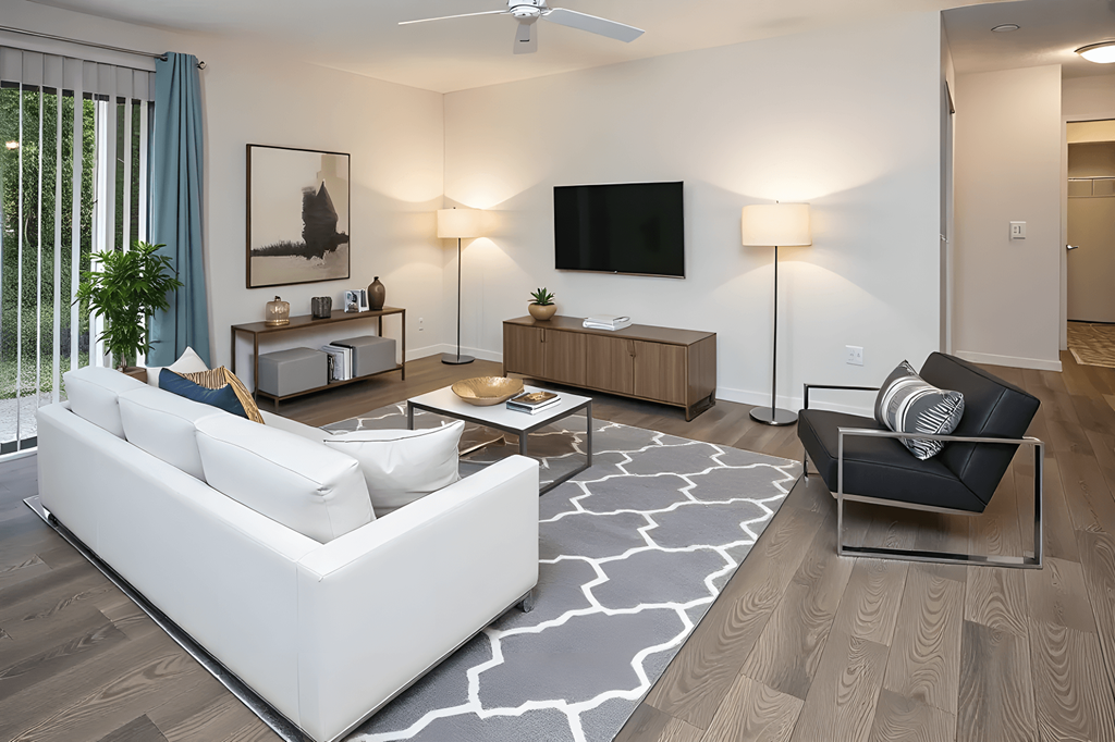 A modern living room with a white sofa, a black armchair, and a television.