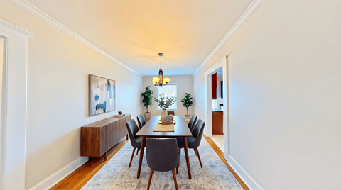 A dining room with a long table and chairs.