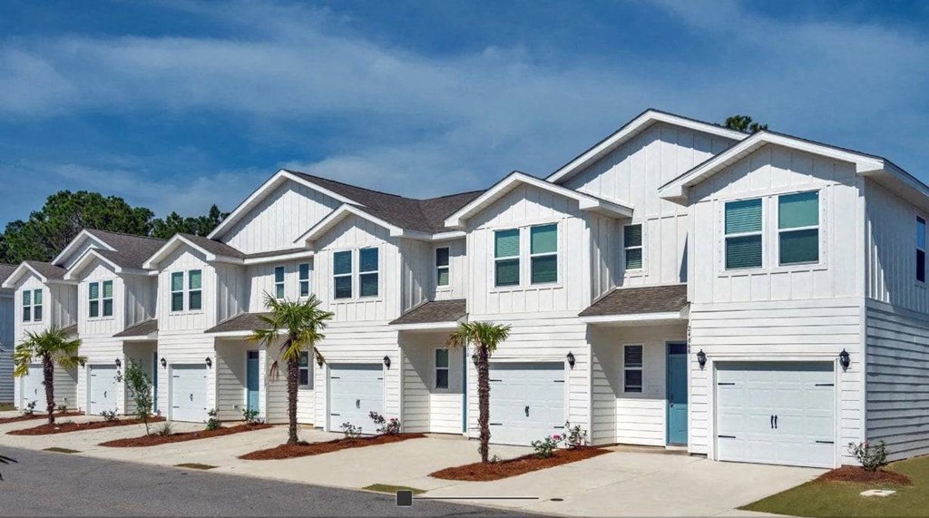 A row of white houses with blue doors and windows.