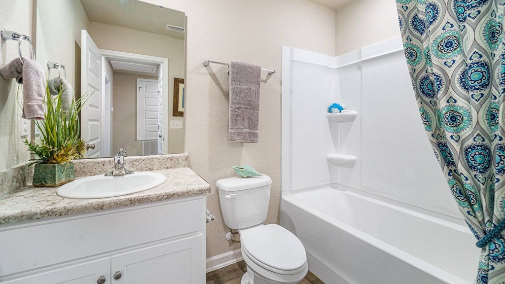 A white bathroom with a white toilet, sink, and bathtub.