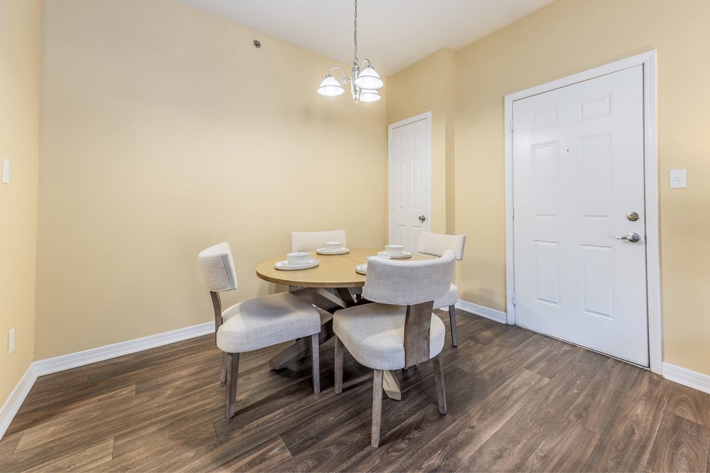 A dining room with a table and chairs.