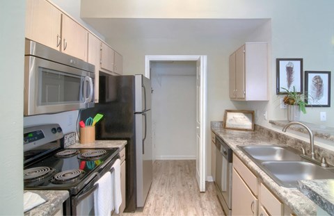 A kitchen with a stove, microwave, and refrigerator.
