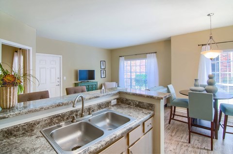 A kitchen with a sink and a dining table.