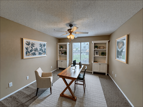 A dining room with a wooden table and chairs.
