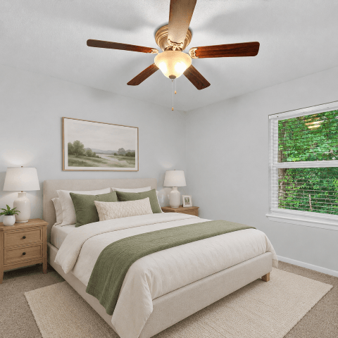 A bedroom with a large bed and a ceiling fan.