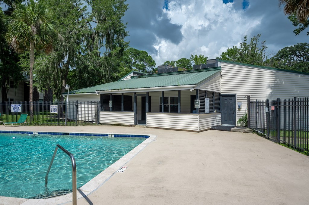 A pool in front of a house with a fence around it at Brackenbrook Apartments, North Charleston, SC
