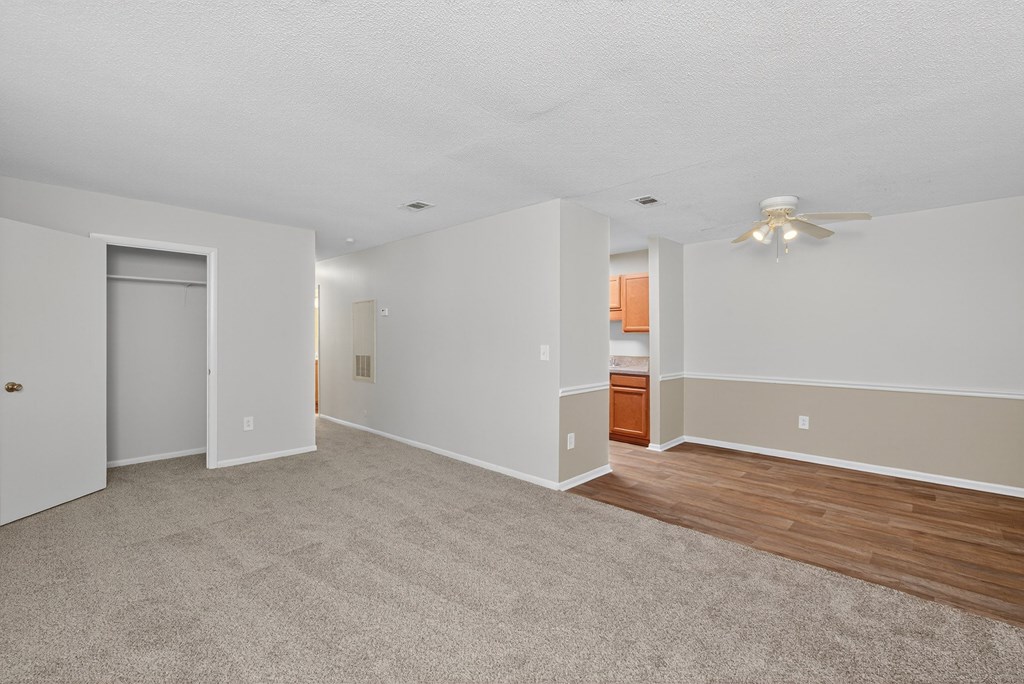 A spacious room with a carpeted floor and a ceiling fan at Brackenbrook Apartments, North Charleston, SC
