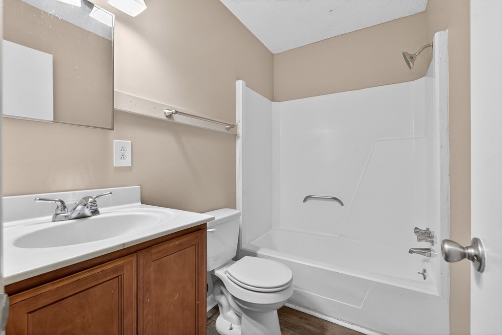 A white sink and toilet in a beige bathroom at Brackenbrook Apartments, North Charleston, South Carolina