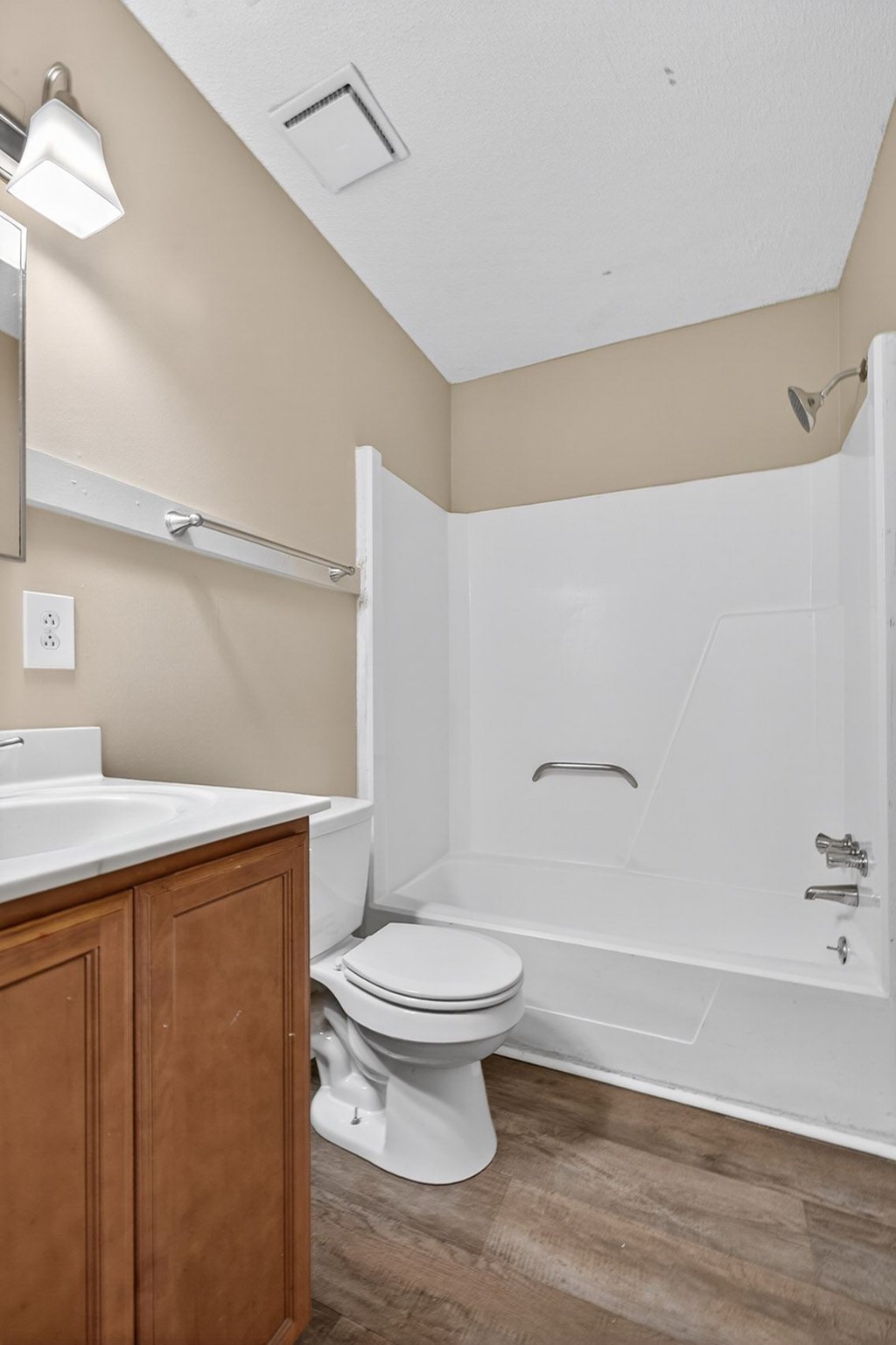 A white toilet sits next to a sink in a bathroom at Brackenbrook Apartments, North Charleston, SC