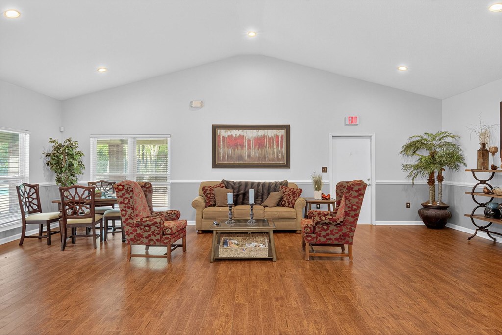 A living room with a large painting on the wall and a variety of chairs and a coffee table at North Bluff Apartments, North Charleston 29406