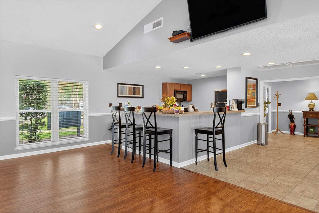 A kitchen with a bar area and a television mounted on the wall at North Bluff Apartments, South Carolina