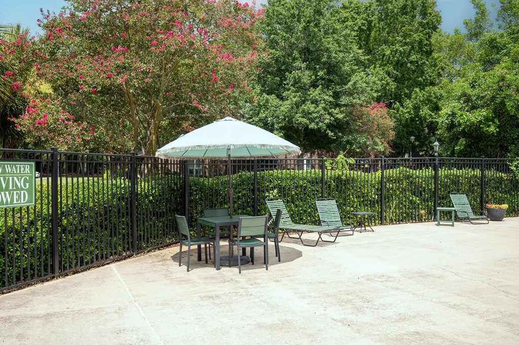 A green umbrella is in front of a black fence at North Bluff Apartments, South Carolina, 29406