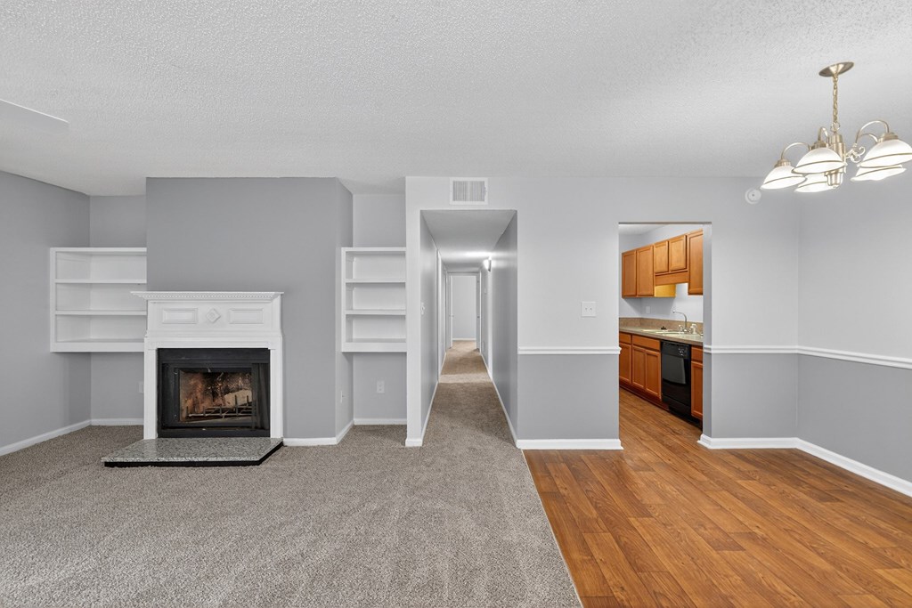 A living room with a fireplace and a hallway leading to a kitchen at North Bluff Apartments, North Charleston 29406
