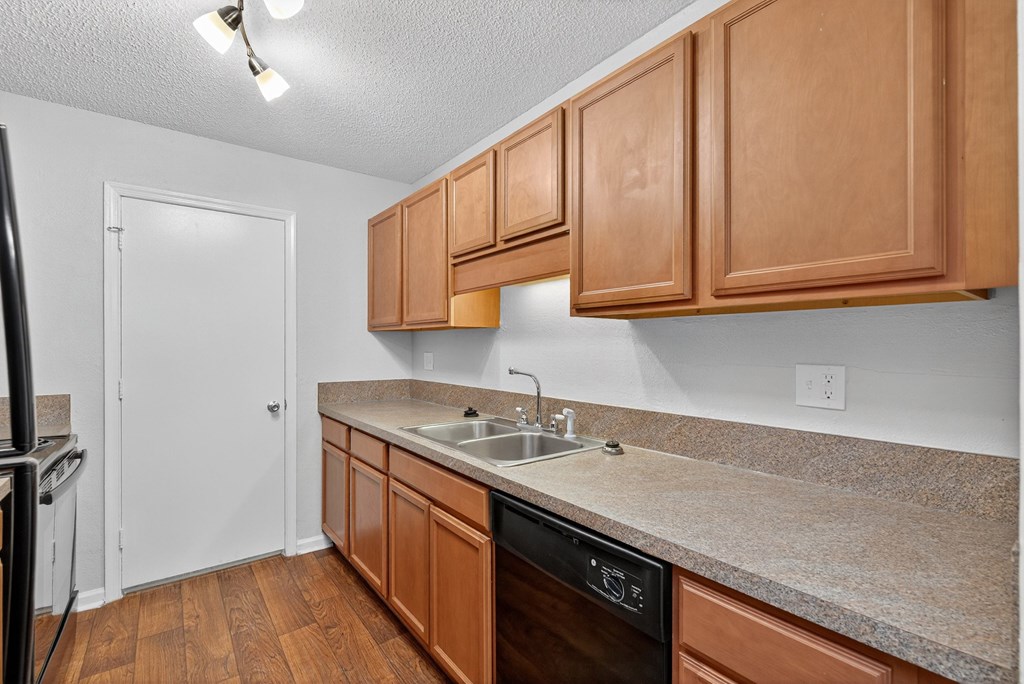 A kitchen with wooden cabinets and a granite countertop at North Bluff Apartments, North Charleston, SC