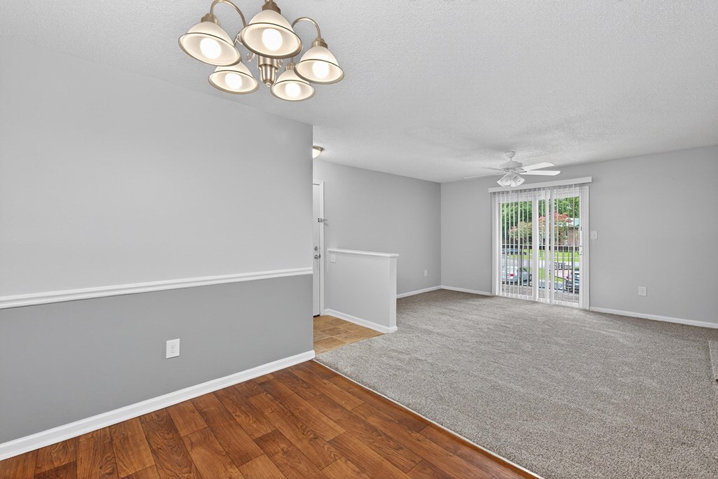 A room with a grey carpet and wooden flooring at North Bluff Apartments, North Charleston