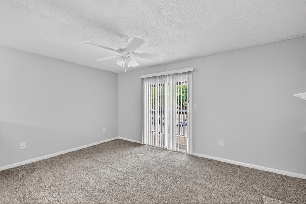 A room with a ceiling fan and carpeted floor at North Bluff Apartments, North Charleston 29406