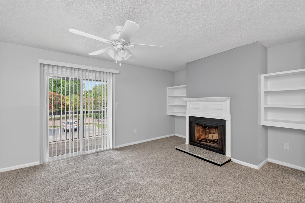 A room with a fireplace and a ceiling fan at North Bluff Apartments, North Charleston, South Carolina