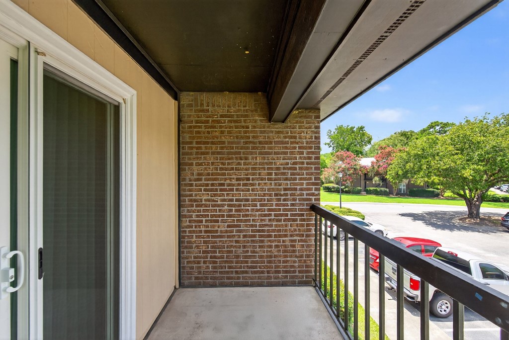 A balcony with a brick wall and a metal railing at North Bluff Apartments, North Charleston, SC, 29406