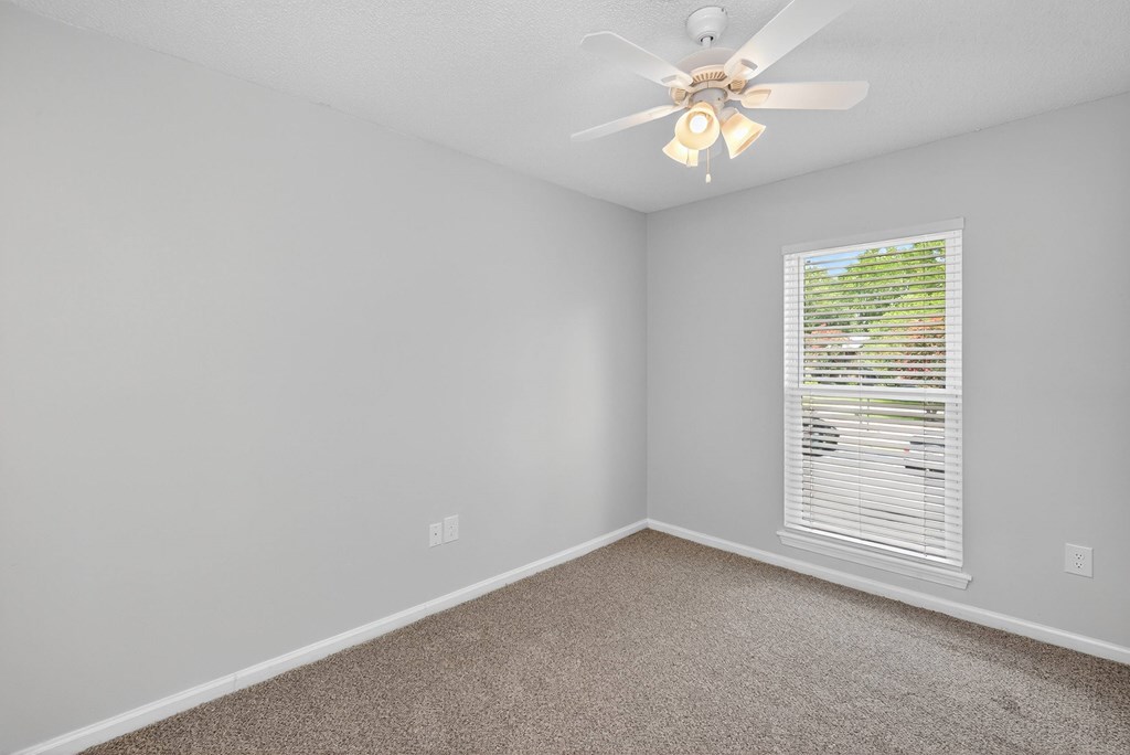 A room with a ceiling fan and a window with blinds at North Bluff Apartments, North Charleston