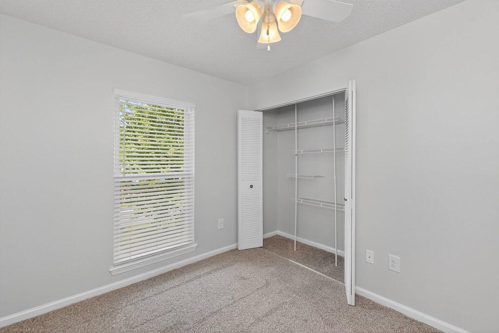 A room with a white door and a window with blinds at North Bluff Apartments, North Charleston, South Carolina