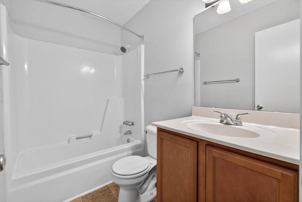 A white bathroom with a toilet, sink, and bathtub at North Bluff Apartments, South Carolina