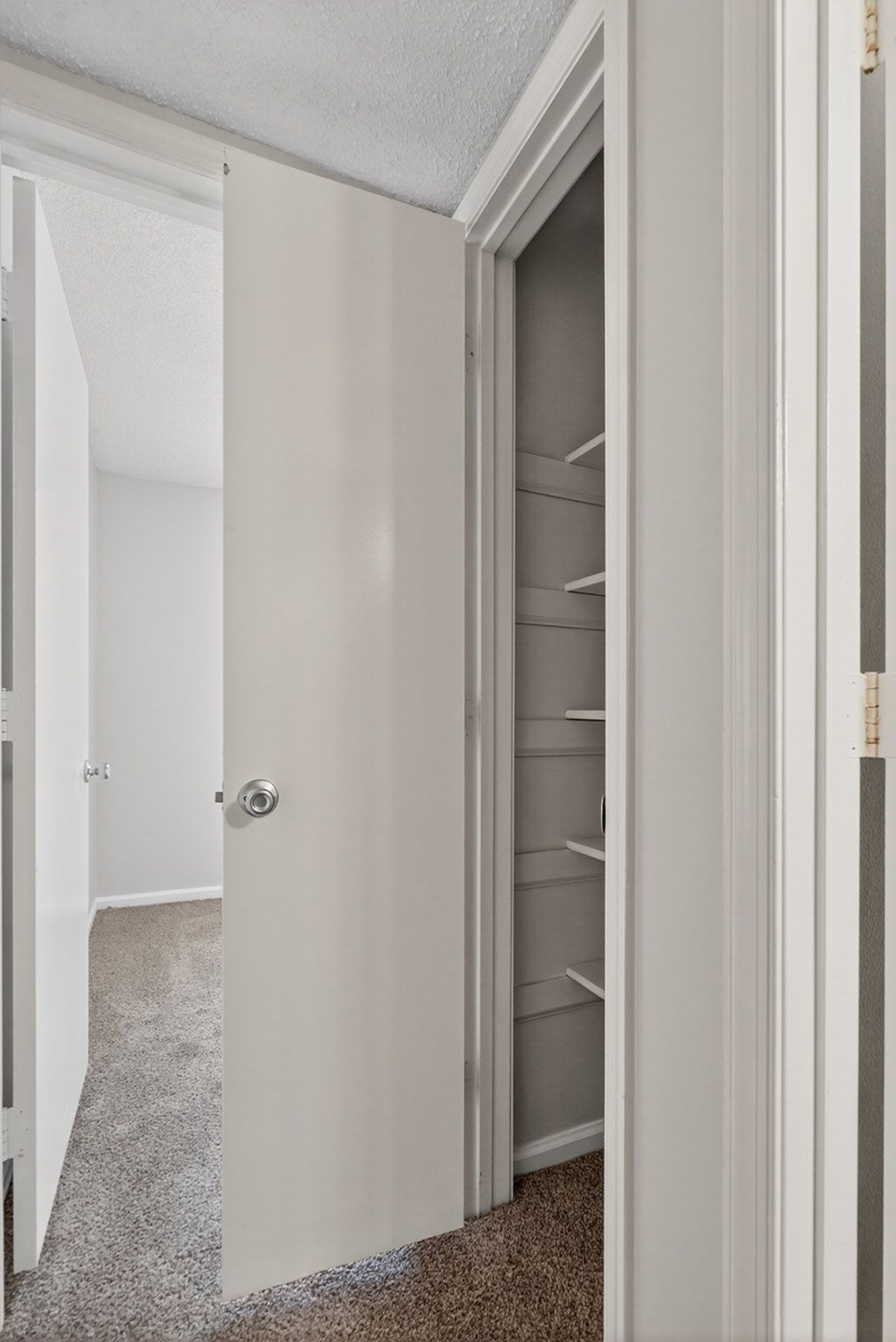 A white door with a silver handle is open. at North Bluff Apartments, North Charleston, SC, 29406