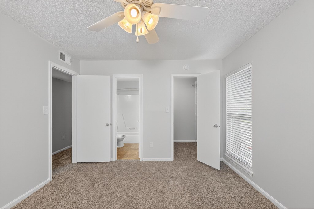 A room with a ceiling fan and carpeted floor at North Bluff Apartments, South Carolina, 29406
