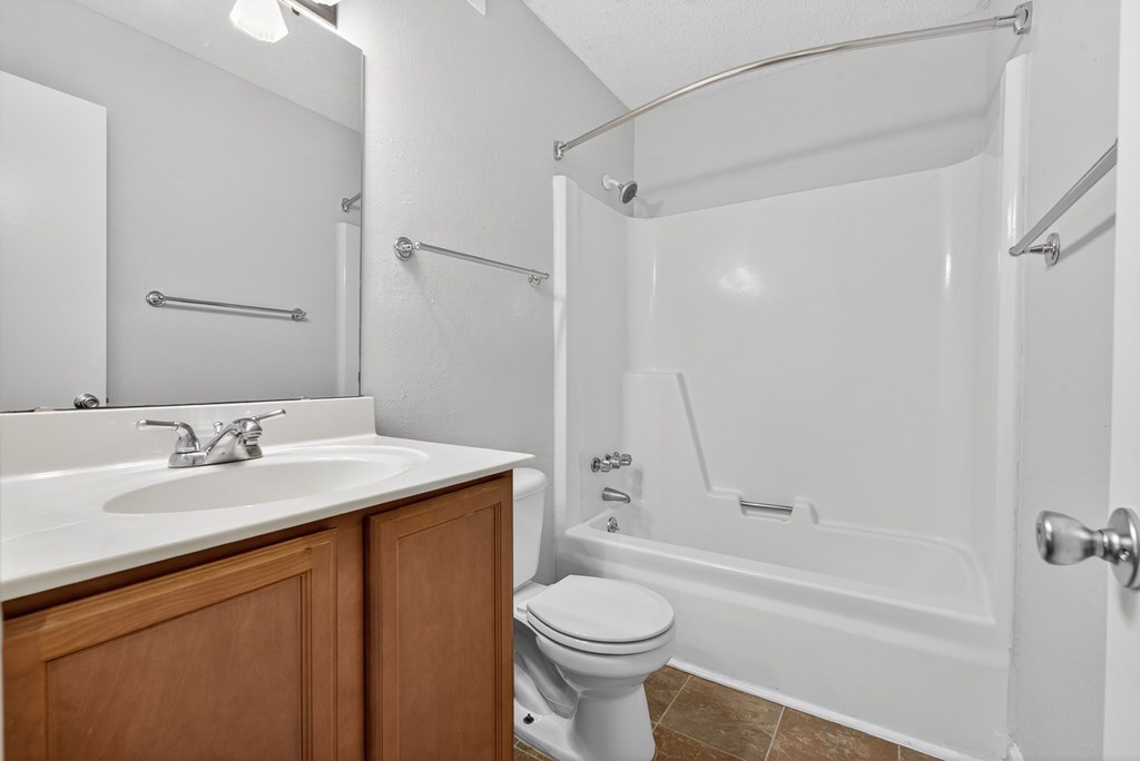 A white bathroom with a toilet, sink, and bathtub at North Bluff Apartments, North Charleston 29406