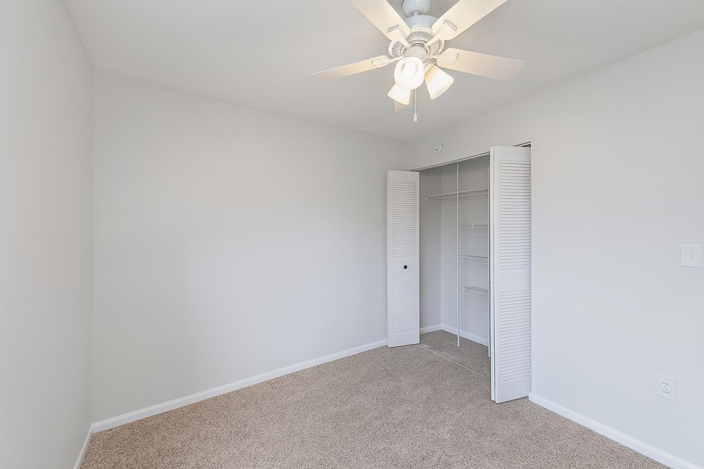 A room with a ceiling fan and carpeted floor at North Bluff Apartments, North Charleston, South Carolina