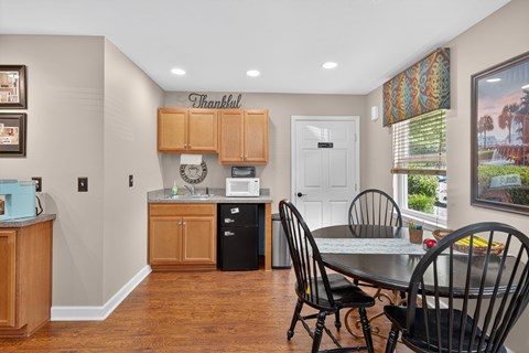 A kitchen with a dining table and chairs.