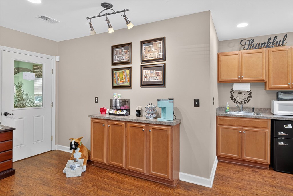 A kitchen with a brown dog sitting in front of a counter at Sawbranch Apartments, Summerville, SC