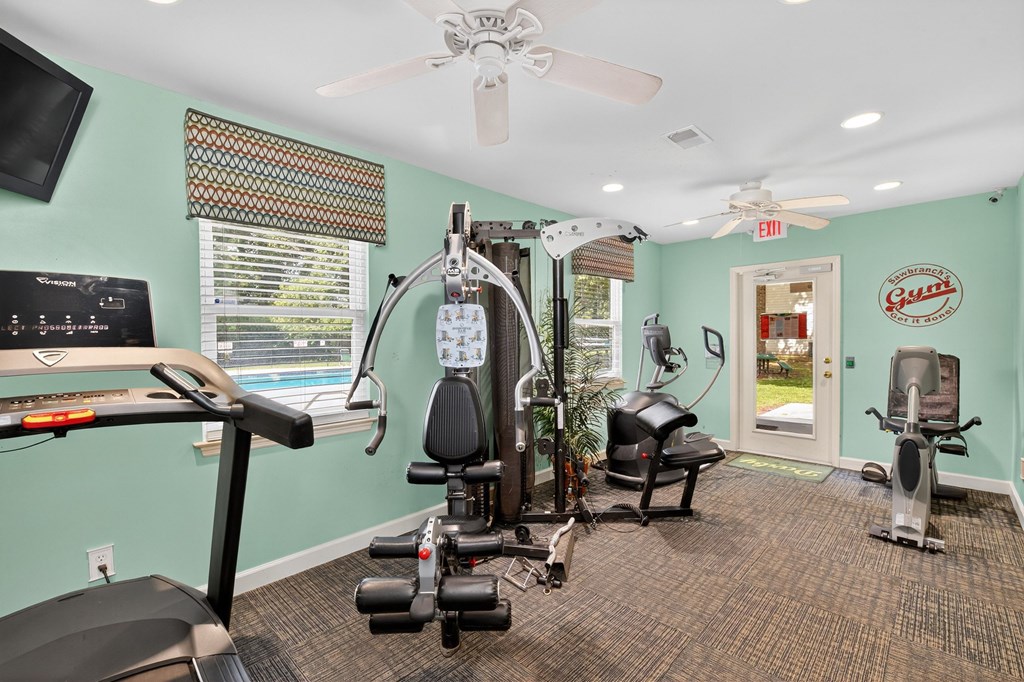 A gym with a treadmill, elliptical machines, and other exercise equipment at Sawbranch Apartments, Summerville 29485