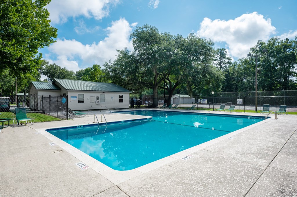 A large swimming pool surrounded by a fence and trees at Sawbranch Apartments, South Carolina, 29485