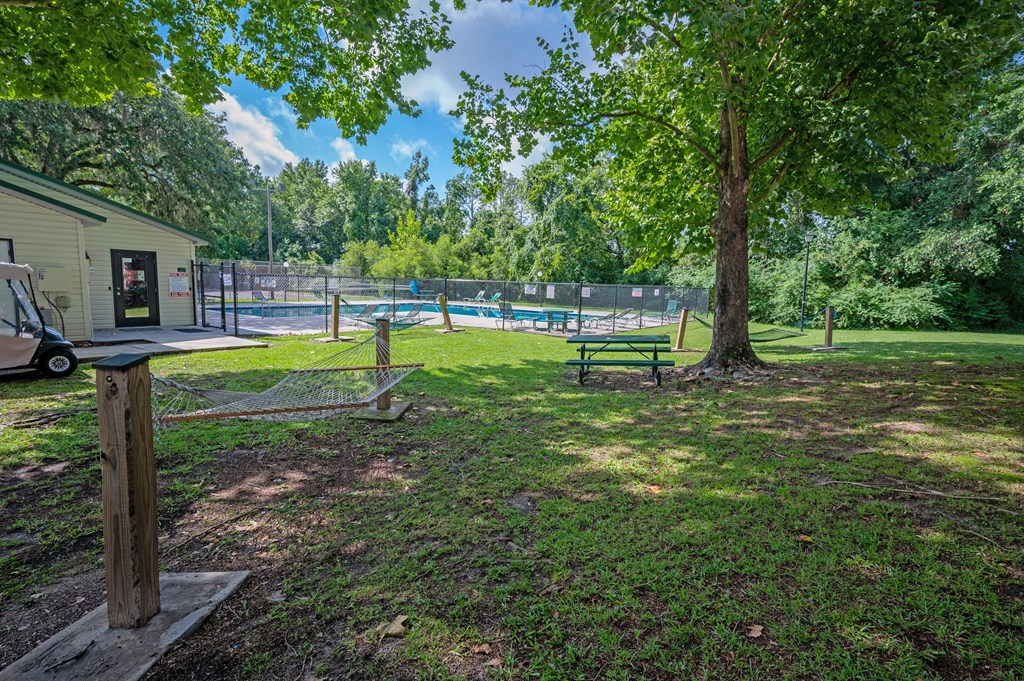 A park with a playground and a tree at Sawbranch Apartments, Summerville, SC, 29485