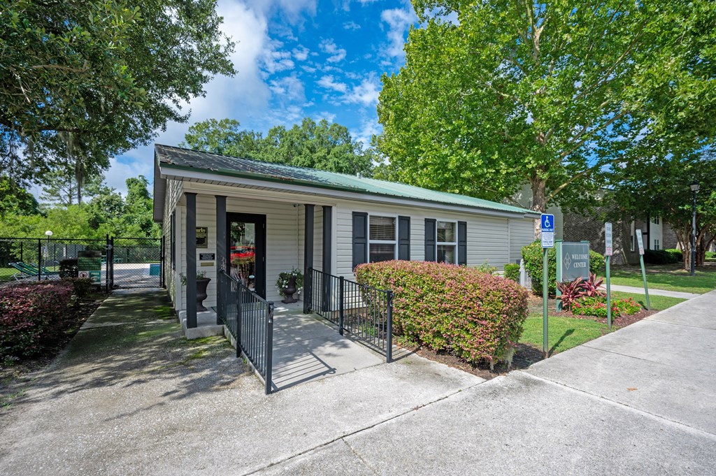 A small building with a green roof and a sign with a wheelchair symbol in front of it at Sawbranch Apartments, Summerville, South Carolina