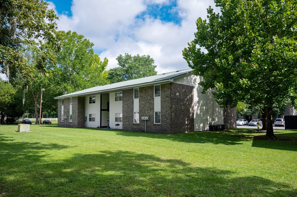 A building with a green lawn in front of it at Sawbranch Apartments, Summerville, SC