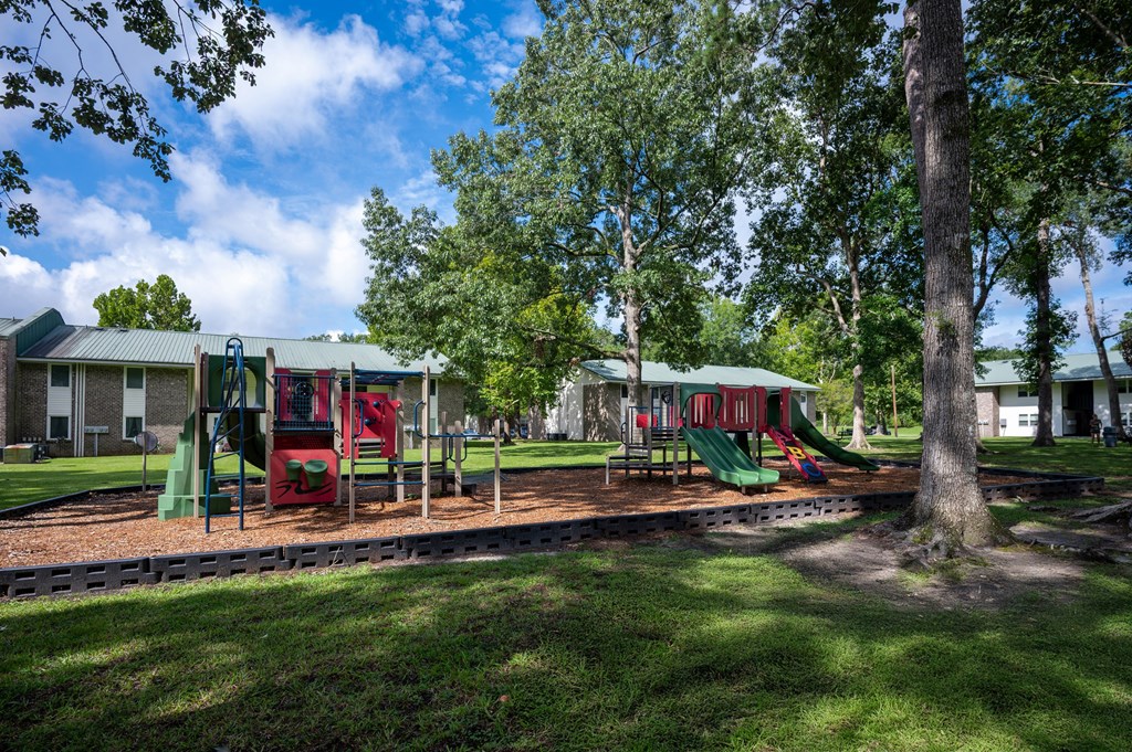 A playground with a red slide and green slide at Sawbranch Apartments, South Carolina
