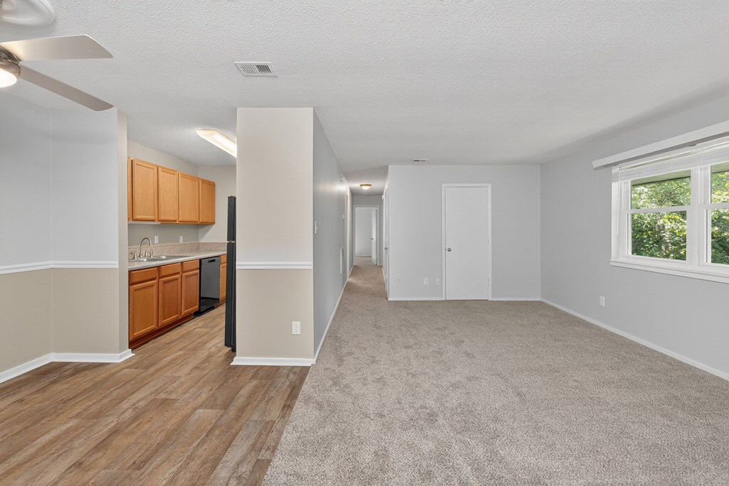 A spacious room with wooden flooring and a carpeted area at Sawbranch Apartments, Summerville, SC, 29485
