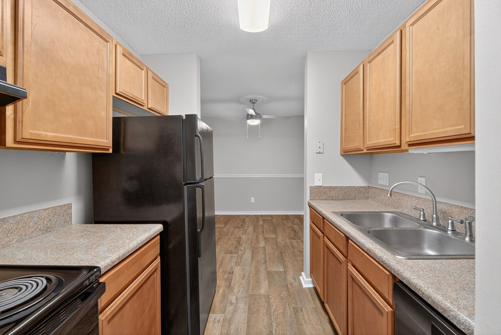 A kitchen with wooden cabinets and a black refrigerator at Sawbranch Apartments, South Carolina, 29485