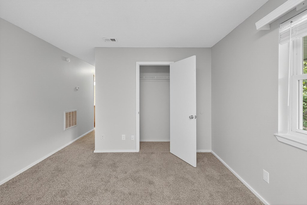 A room with a carpeted floor and a doorway leading to another room at Sawbranch Apartments, Summerville