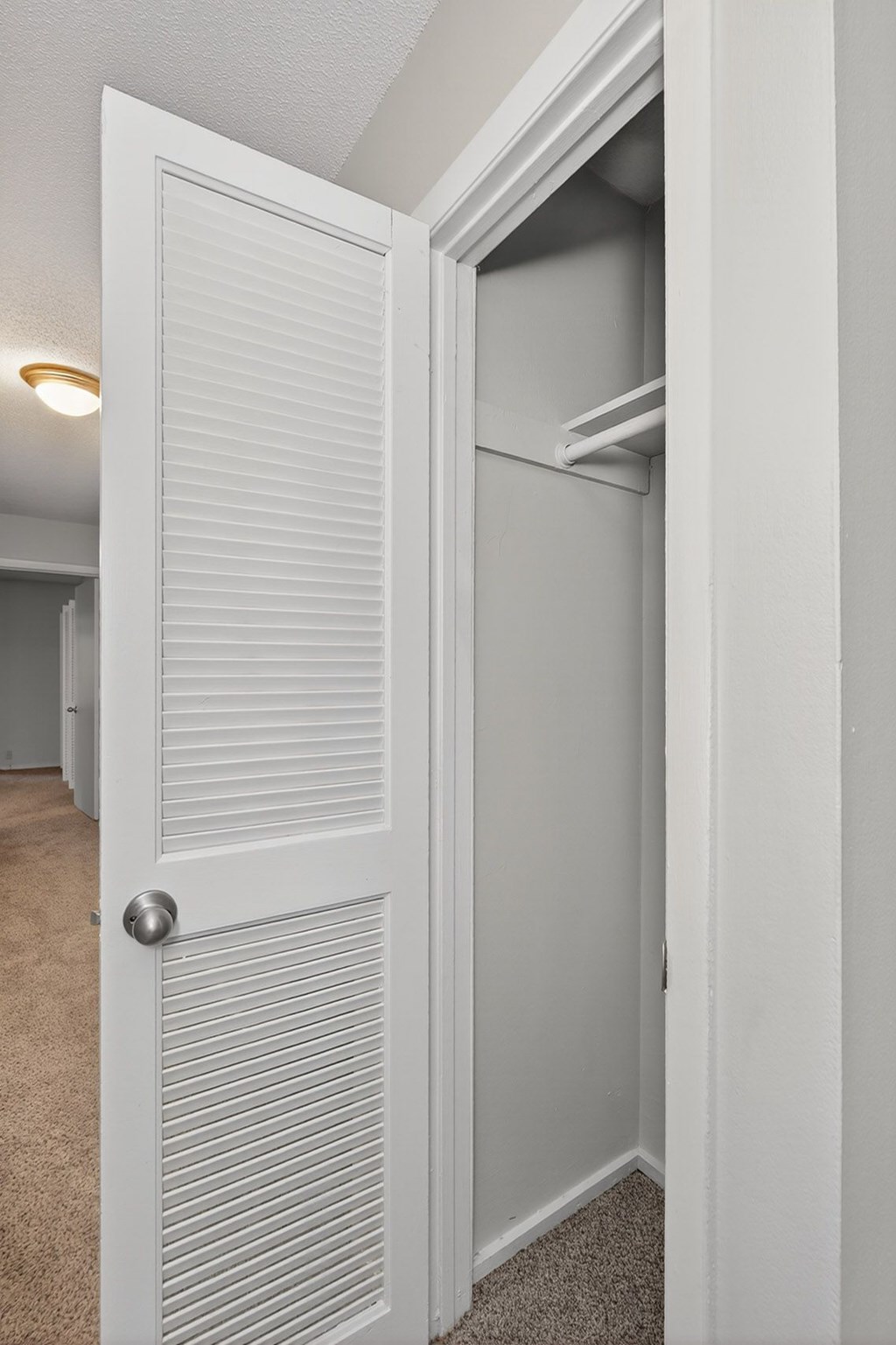 A white door with a silver handle is open at Sawbranch Apartments, Summerville, South Carolina
