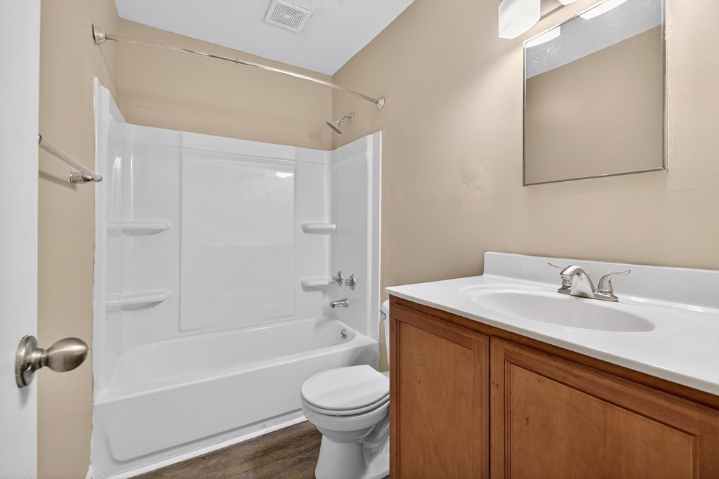 A white toilet sits next to a white sink in a bathroom at Sawbranch Apartments, South Carolina, 29485