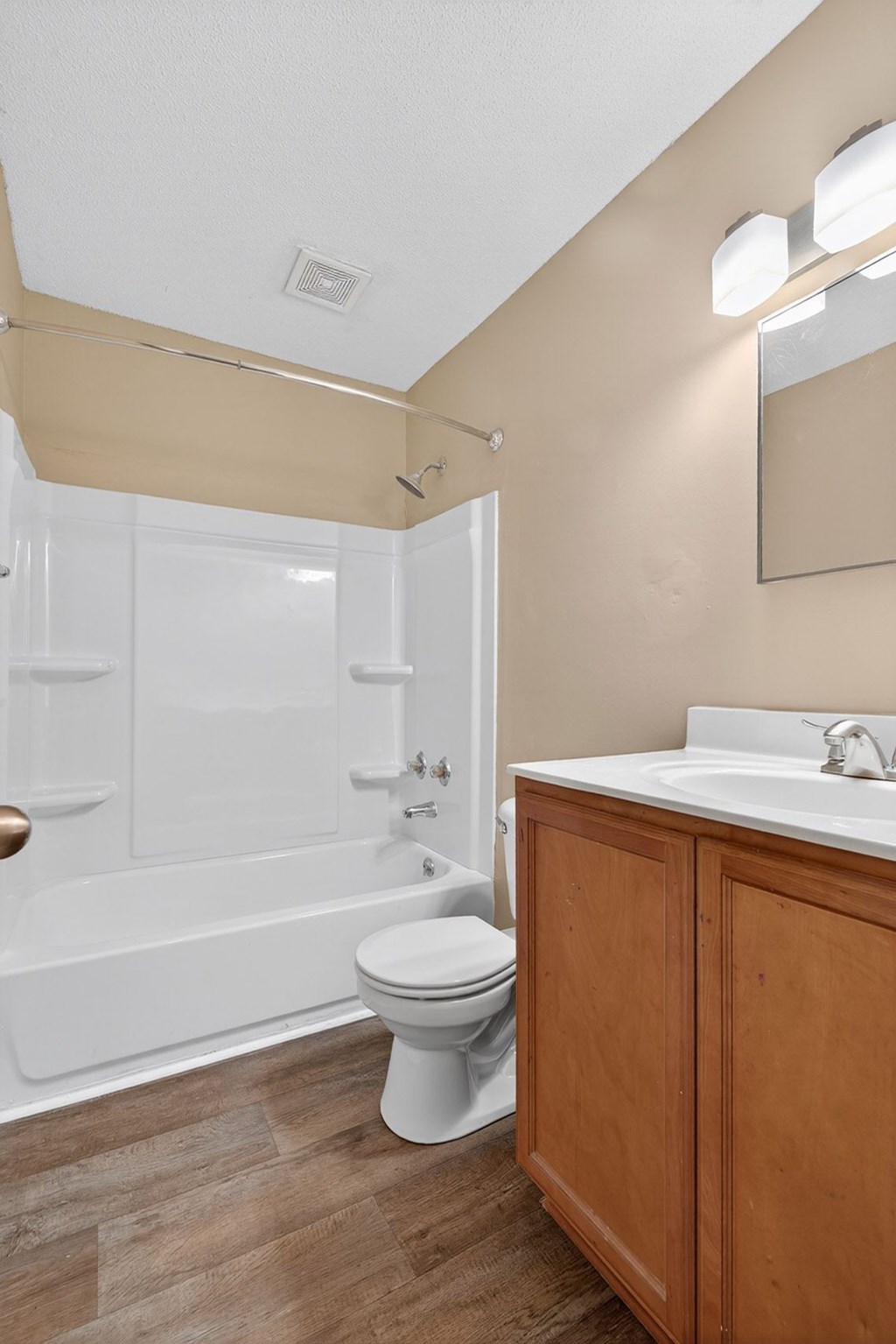 A white toilet sits next to a sink in a bathroom at Sawbranch Apartments, Summerville, SC