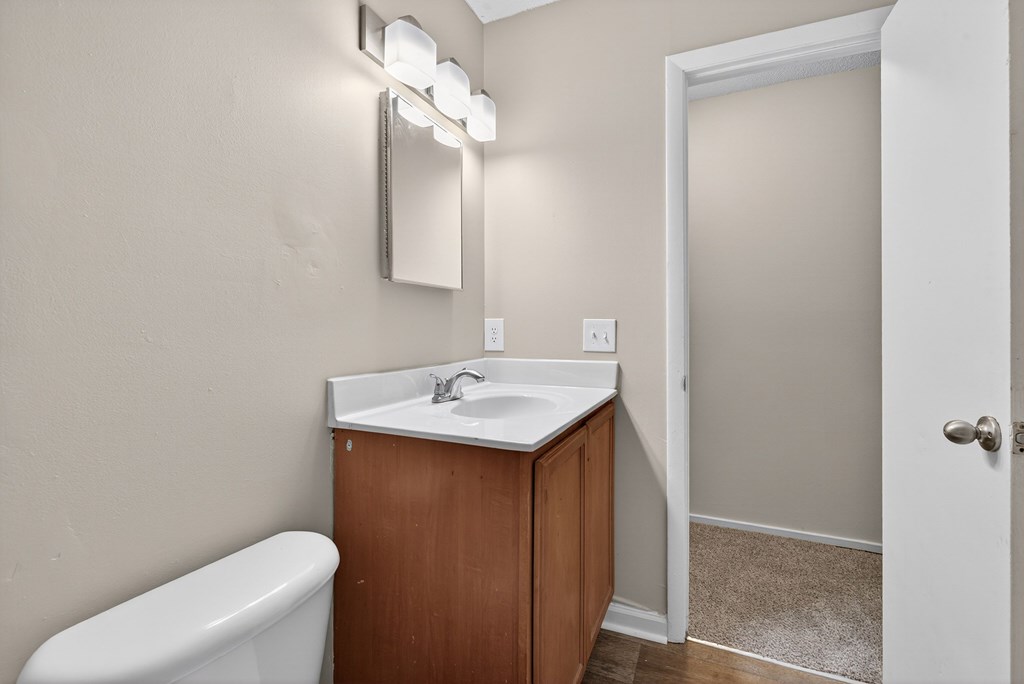 A white sink is on a wooden cabinet in a bathroom at Sawbranch Apartments, Summerville, SC, 29485