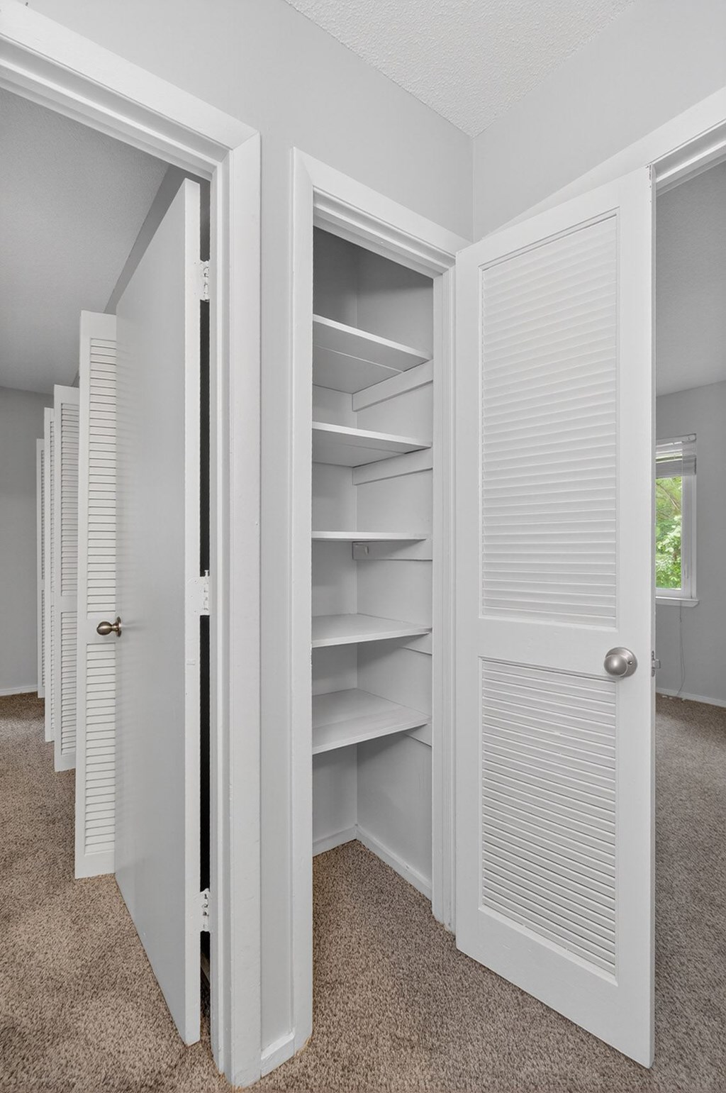 A row of white pantry doors are open at Sawbranch Apartments, South Carolina
