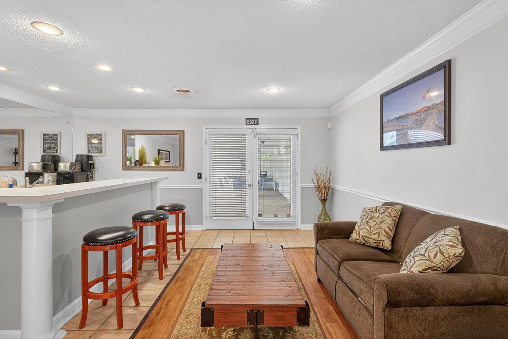 A living room with a couch, a bar, and a painting on the wall at The Landing Townhomes Apartments, South Carolina