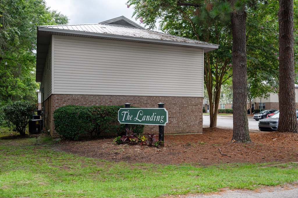 A small building with a sign that says The Landing in front of it at The Landing Townhomes Apartments, South Carolina, 29410