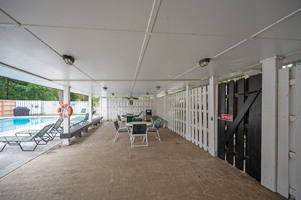 A patio area with a pool and a table set up for dining at The Landing Townhomes Apartments, South Carolina
