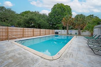 A rectangular pool with a wooden fence surrounding it at The Landing Townhomes Apartments, South Carolina