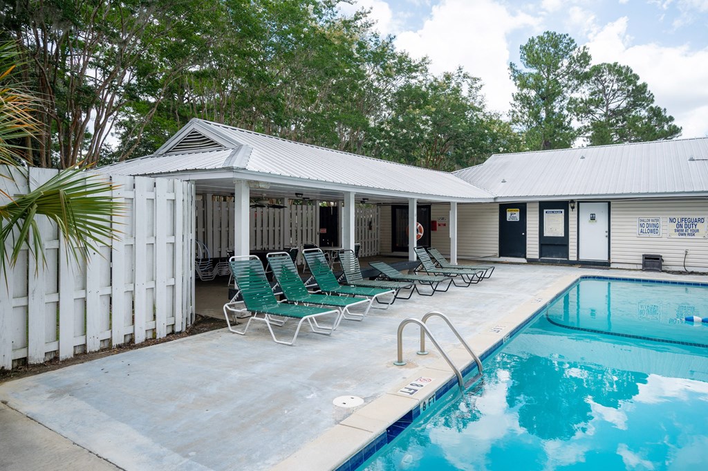 A pool area with a white fence and green chairs at The Landing Townhomes Apartments, Hanahan, SC, 29410